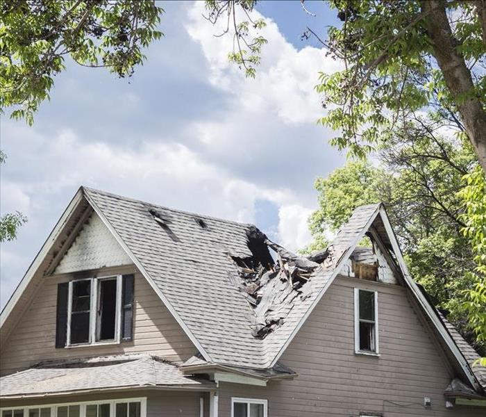 A home with roof damage caused by a fire.