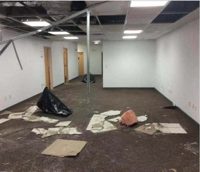 Empty office room, ceiling collapsed, debris on floor